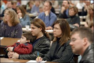 Aleca Kamilaris, son Andreas, 5, and friend Trudy Cox hear the new plan, in which Andreas will stay at Highland Elementary.
