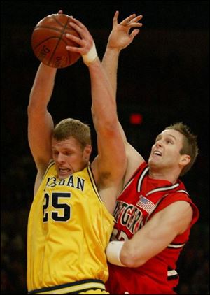 Michigan's Graham Brown grabs one of his five rebounds in front of Rutger's Sean Axani last night at Madison Sqaure Garden.