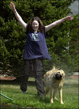 ROV HAIR SPRAY 4/7/04 PHOTO BY LORI KING Sylvania resident Kelsey Lowden, 13, reacts to being sprayed by her dog, Molly, who was just given a bath in Kelsey's Deepwood Dr. driveway. It was Molly's first outside bath of the season.