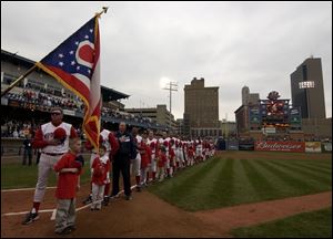 Manager Larry Parrish and the rest of the Mud Hens listen to the National Anthem during pregame ceremonies.