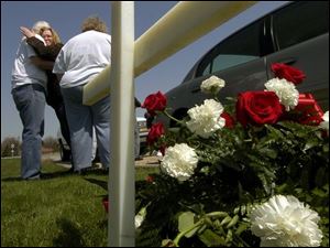 cty wreath15p 2 April 15, 2004.  Bill Grote, father of Janice James, hugs his daughter Grace Hawkins as Grace Grote, mother of Janice James, stands close by on  Crabb Road near Sterns Thursday afternoon at a road side memorial. Janice James was killed by a drunk driver. Blade photo by Jeremy Wadsworth