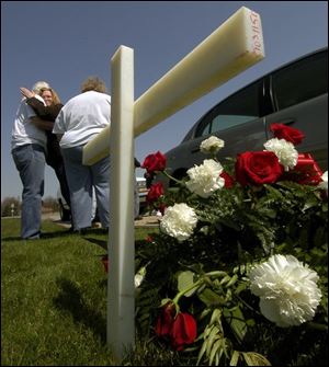 cty wreath15p 2 April 15, 2004.  Bill Grote, father of Janice James, hugs his daughter Grace Hawkins as Grace Grote, mother of Janice James, stands close by on  Crabb Road near Sterns Thursday afternoon at a road side memorial. Janice James was killed by a drunk driver. Blade photo by Jeremy Wadsworth