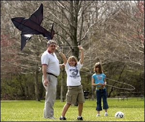ROV April 16, 2004 - Shannon Collins, 10, center, and her sister Brooke Collins, 8, try to get their kite airborn in Sidecut Metropark Friday afternoon.  Dad Jim Collins is holding the string too. They are from Springfield Township.  Blade photo by Dave Zapotosky.