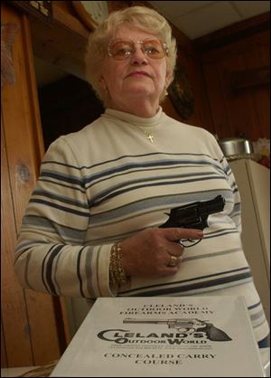 Mary Lou Krause of Swanton Township holds her snubnose .38 revolver at the ready in her home after passing a concealed-carry training course.