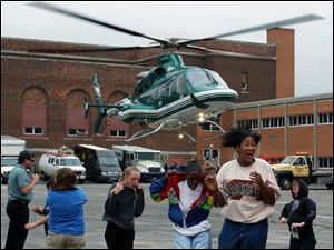 Birmingham School students run from the winds created when the ProMedica helicopter took off from the school parking lot during 'vehicle day' at the east side school. Lisa dutton 05/07/2004 CTY helicopter.jpg