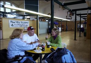 Dena and Tony Mirenda, left, eat lunch with their daughter Mary Wendt in a virtually empty Erie Stret Market. A consultant recommends a $5 million renovation to turn things around.