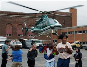 Birmingham School students run from the winds created when the ProMedica helicopter took off from the school parking lot during 'vehicle day' at the east side school. Lisa dutton 05/07/2004 CTY helicopter.jpg