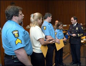 Toledo Police Chief Michael Navarre, right, honors Officer Shelli Kilburn, as Sgt. Edward Mohr, left, and Officers Brenda Sarahman and Thomas Corser look on. The latter three officers were honored for coming to the aid of Officer Kilburn, who had been shot on Feb. 26.