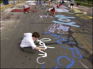 Continuing a Bluffton High ritual, John Sylak paints his name on College Avenue.
