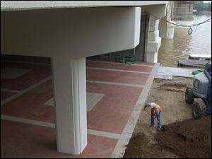 Cty  rove  Maumee River on Water St. near Maritime Bldg.  A worker does some finishing touches on the plaza under the MLK bridge.  Diane Hires  5/28/04