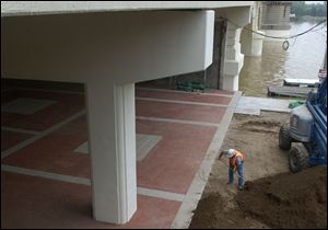 Cty  rove  Maumee River on Water St. near Maritime Bldg.  A worker does some finishing touches on the plaza under the MLK bridge.  Diane Hires  5/28/04