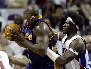 The Lakers' Shaquille O'Neal, left, tries to keep the ball away from the Pistons' Ben Wallace in the second half of Game 3 of the NBA Finals, where O'Neal was limited to 14 points and 8 rebounds by Detroit's determined dominating defense.