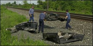 Workers remove debris from a vehicle that was struck by a train in Fulton County.
