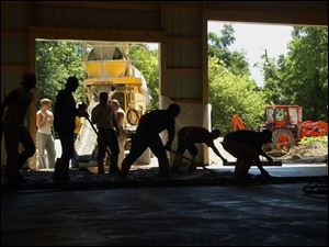 CTY BARN19P 1 6/19/04 PHOTO BY LORI KING Ironworkers  pour the floor for a  pole barn being built for injured ironworker Roger Henneman at his Rialto Rd. home.