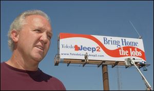 Local 12 president Bruce Baumhower touts the Toledo Loves Jeep effort near a new billboard at Monroe and 11th Streets.