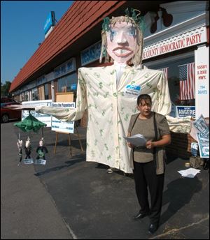 Reg Photo by Don Simmons July 1, 2004   Mary Ann Neopolitan Monroe County Democratic Party Chairman speaking at the news conference held at their party headquarters on South Monroe St in Monroe,Mich about the Besty DeVoss puppet behind her    ( DeVoss01p )