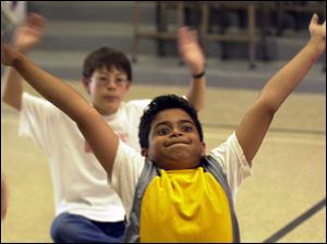 ROV commonspace02p 02 - 07/02/04- Nine-year-old Kiran Venkat, of Perrysburg, streches his arms and his face while preparing for a dance lesson at a creativity camp at Common Space Center for Creativity in Toledo Friday afternoon.  The camp included various painting, ceramic, and dance techniques and ended the week with an exhibition of work and preformance for parents.