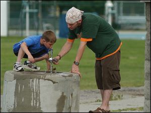 Seven year old Bryce Hess gets a helping hand for a drink of water from his older brother Ryan Hess at Delta Community Park Thursay afternoon. Lisa dutton 06/03/2004 NBR Delta rover .jpg