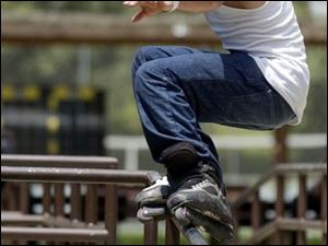 ROV July 6, 2004 - Mike Currier, 22, of Toledo, lands on one rail after jumping from another at Jermain Park Tuesday afternoon.  He and two friends were practicing their inline skating.  Mike says he is on the K2 Skate international amateur team.  K-2 Corp.  sells a variety of products including skates, he says.  Blade photo by Dave Zapotosky