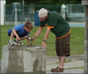 Seven year old Bryce Hess gets a helping hand for a drink of water from his older brother Ryan Hess at Delta Community Park Thursay afternoon. Lisa dutton 06/03/2004 NBR Delta rover .jpg