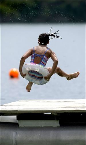 ROV regionkid 02 - Mia Richardson, 9, of Toledo, jumps off the dock as she enjoys the warm weather at Portage Quarry in Portage, OH, just south of Bowling Green, with her aunt, Michelle Finley as they. Allan Detrich/The Blade