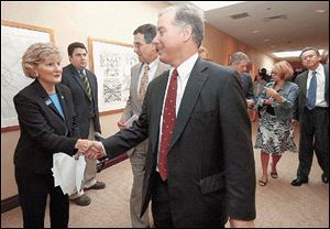 Ohio state Sen. Teresa Fedor shakes hands with former presidential candidate Howard Dean before attending a conference during the Democratic National Convention in Boston on independently auditable voting systems .