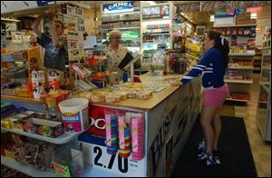 Brittany Anderson chats with Diane Hudson, behind the counter, as she returns a video. Brittany had worked at the store. 