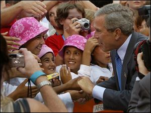 President Bush greets members of the Afghan girls soccer team after speaking at the Athletes of the International Children's Games and Cultural Festival at Cleveland Browns Stadium.