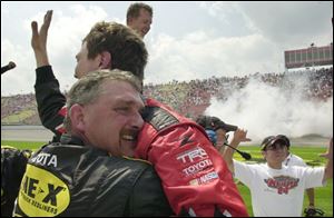 Crew members celebrate Toyota's first win of the season in the NASCAR Craftsman Truck Series. Travis Kvapil, the defending champion in the Craftsman Truck Series, won the Line-X 200.