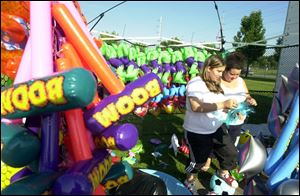 Miranda Wodarski, left, and her cousin, Chelsea Hafner, arrange prizes for their grandparents' game of chance at the fair.