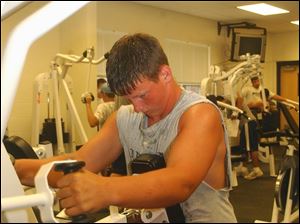 Josh Cutcher, an incoming senior at Lake High School, lifts weights in the school's weight room to get ready for a football season that may never come because of the defeat of a levy proposal.