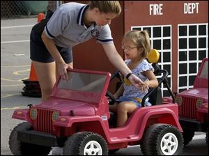 NBR July 21, 2004 - Maumee police officer Wendy Newsome shows Ashli Mengel, 4, the proper way to signal a left turn during the Maumee Safety City at Fort Miami School.   Blade photo by Dave Zapotosky  safety21p