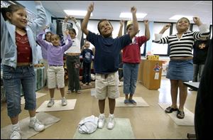 CTY migrant28p A  July 28, 2004-- Vanessa Aguayo,  left, Hector Mena, center, and Monica Gomez,  right, and classmates dance along with music teacher Julie Zedlitz during summer school for children of migrant workers. The three eight year-olds and their classmates were having fun learning Wednesday morning at the class in Delta. Blade photo by Andy Morrison