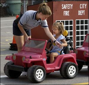 NBR July 21, 2004 - Maumee police officer Wendy Newsome shows Ashli Mengel, 4, the proper way to signal a left turn during the Maumee Safety City at Fort Miami School.   Blade photo by Dave Zapotosky  safety21p