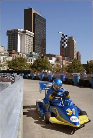 The driver of the TARTA race car opts not to take the bus route during preliminary heats of the Junior Achievement Grand Prix in downtown Toledo. The races were held along the Maumee River at the headquarters of Owens Cornings.