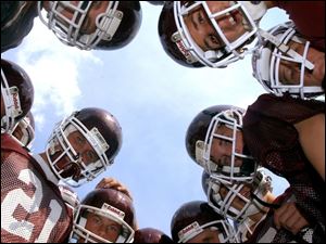 Spt  hsfoot10p  Rossford football practice.  Freshman players huddle to show their enthusiam.   Diane Hires  8/9/04