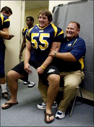 SPT August 10, 2004 - University of Toledo football coach Tom Amstutz playfully puts St. John's Jesuit High School graduate Andrew Decker on his lap while posing for a portrait on team  picture day at the Glass Bowl.  Blade photo by Dave Zapotosky  UTfoot11p