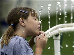 ROV August 10, 2004 -Kristen Murray, 8, gets a drink while waiting for her dad Steve Murray, the University of Toledo strength and conditioning coach, who was being photographed with other  coaches and players on team picture day at the Glass Bowl.  Blade photo by Dave Zapotosky  UTfoot11p