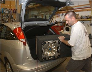 Steve Boldt fits a 15-inch speaker into a trunk, but the vehicle owner will have to keep the volumn down.