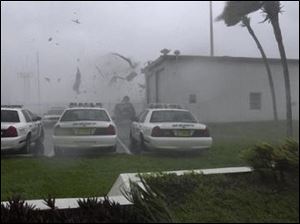 The roof of a garage is blown off onto Charlotte County Sheriff's cruisers from winds of Hurricane Charley in Punta Gorda, Fla.