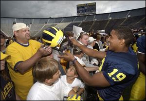 Scott graduate Willis Barringer signs autographs at Michigan's media day yesterday.