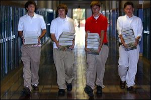 CTY SCHOOL16P 1 8/16/04 PHOTO BY LORI KING from left: Central Catholic sophomores Ryan Gast, Jorden Stanley, Ryan Kaminski and Patrick Kurtz carry biology books to their classroom during 1st period of school.