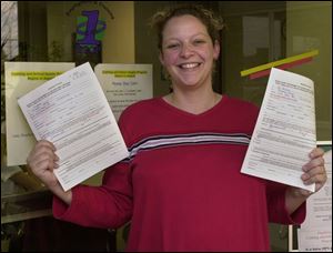 Fostoria resident Amanda James beams as she displays the $550 worth of vouchers that she received.
