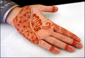 Henna-type tattoos are offered by Mehuish Durrani during the International Festival at the Islamic Center in Perrysburg.
