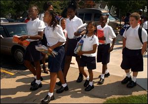 Students wearing school uniforms leave the Old West End Academy last week after the first half day of classes. This year, all TPS elementary schools will require uniforms. 