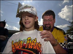 Racer Randy Kleikamp autographs a T-shirt worn by Bridget Sevitz, 10, of Lima, at the Wood County Fairgrounds.