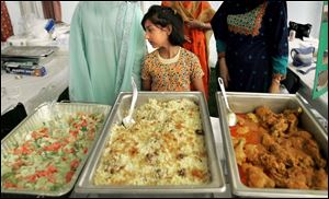 NBR islam22p 04 - Rayat Ahmed, 8, in one fo rthe international food booths at the International festival at the Islamic Center. Allan Detrich/The Blade