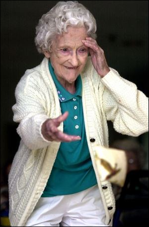 NBR olympic20p 01 -08/20/04- Ruth Manor, who is legally blind, shields the light from her eyes as she tosses a bean bag during the Senior Olympics program at Perrysburg Commons Retirement Center Friday afternoon.  The center is holding a different  Olympic event each day including, watermelon spitting, frisbee toss and employyee wheel chair races.  (Blade photo by Melanie Maxwell)