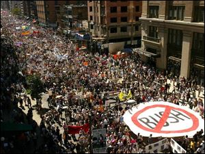 An anti-Bush banner makes its way with marchers down Seventh Avenue.