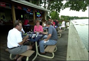 IN THE SPOTLIGHT: From lower left, Paul and Cindy Sobb dine with friends Nancy and Greg Scott and enjoy each other's company on the upper deck of Lighthouse Cafe on Broadway.